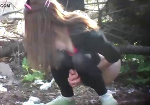 Gorgeous brunette MILF is pissing on the ground on camera